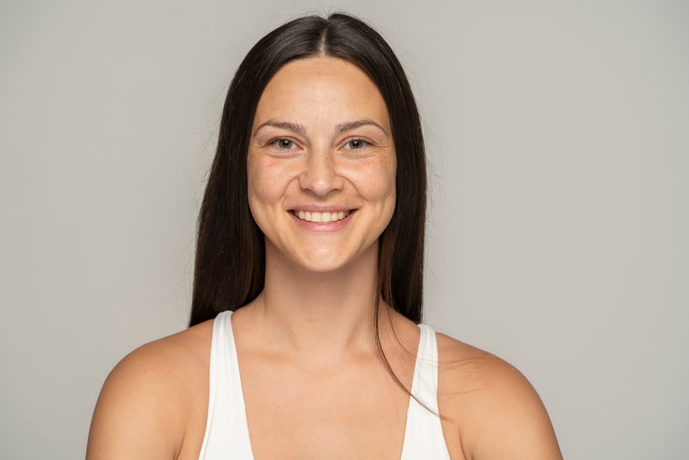 Woman with clean, makeup-free skin smiling, representing ideal preparation for Botox injections.
