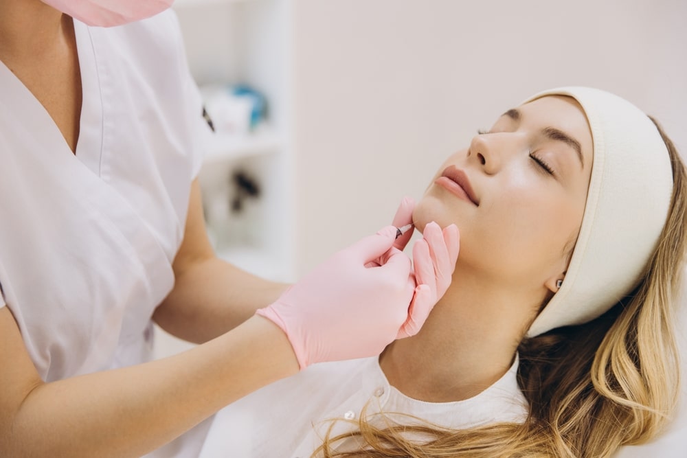 Patient receiving Botox injection with closed eyes, showing typical mild post-treatment effects like redness or swelling.